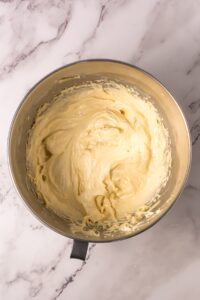 A metal bowl filled with thick, creamy batter on a marble surface.