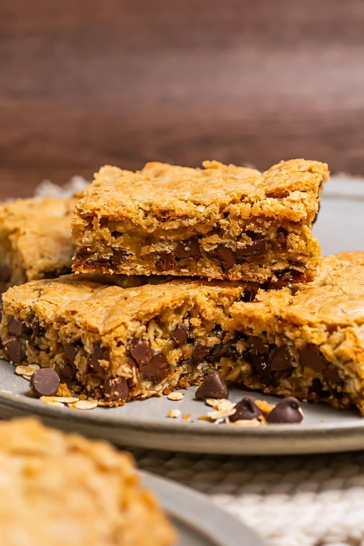 Chocolate chip cookie bars stacked on a plate, showing their chewy texture.