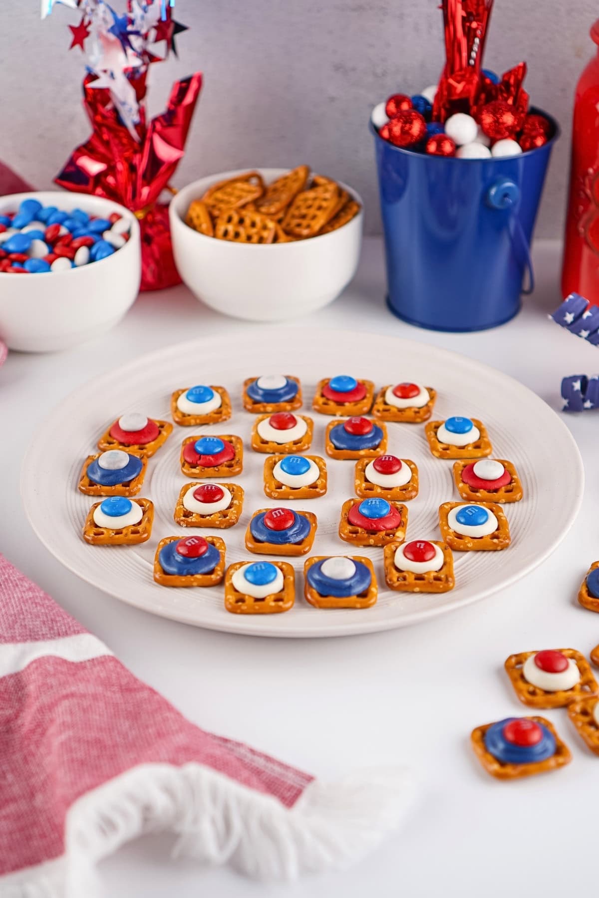 Plate of pretzel snacks with red, white, and blue candy on a festive table.