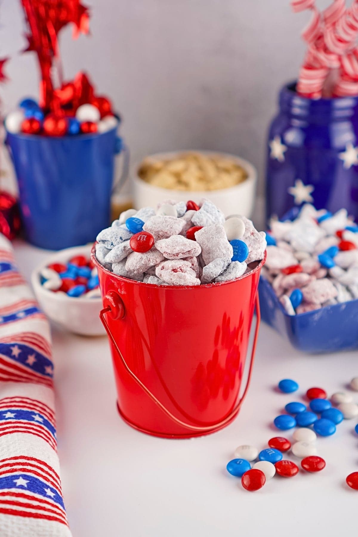 Red bucket with patriotic candies and snacks, decorated in red, white, and blue.