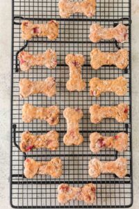 Bone-shaped dog treats on a wire cooling rack.