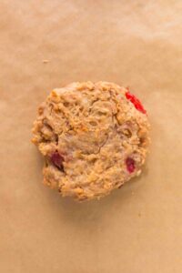 Unbaked oatmeal and berry cookie dough on parchment paper.