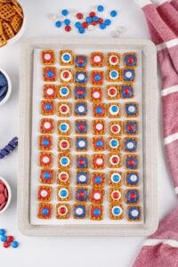 A tray of pretzel treats topped with red, white, and blue MMs and candy melts.