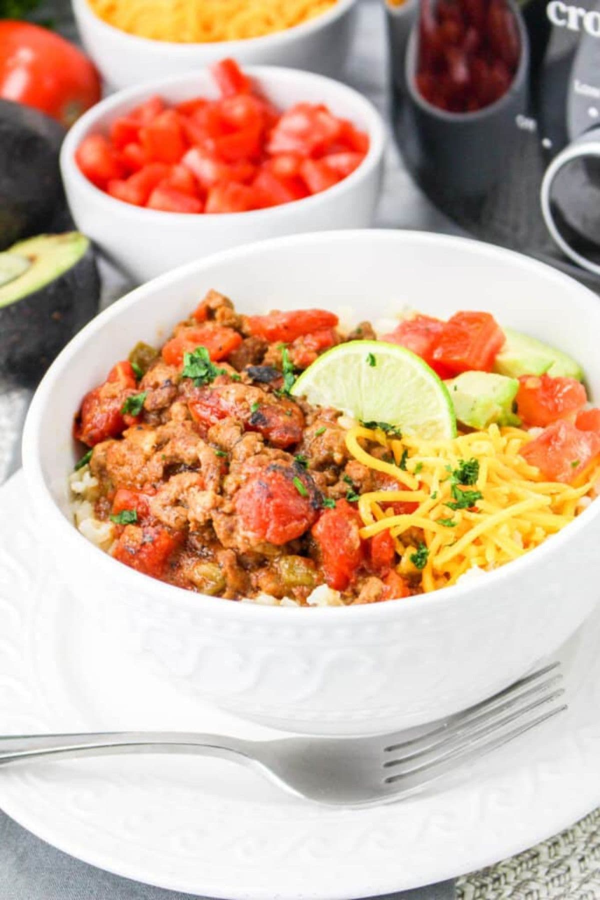 A burrito bowl with ground beef, rice, cheese, and spring slow cooker flavors.