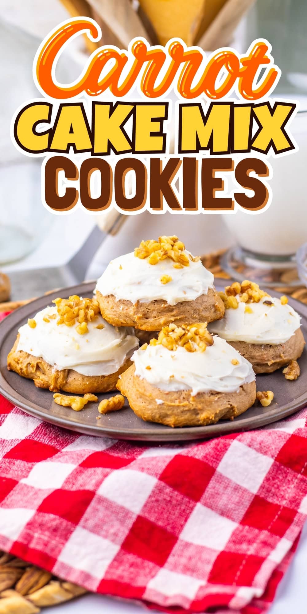 Plate of carrot cake cookies with frosting and nuts on a red checked cloth.