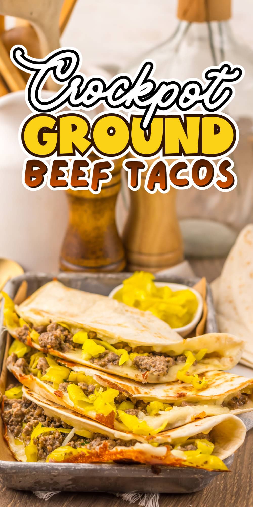 Tacos filled with ground beef and yellow peppers on a tray with text on top.