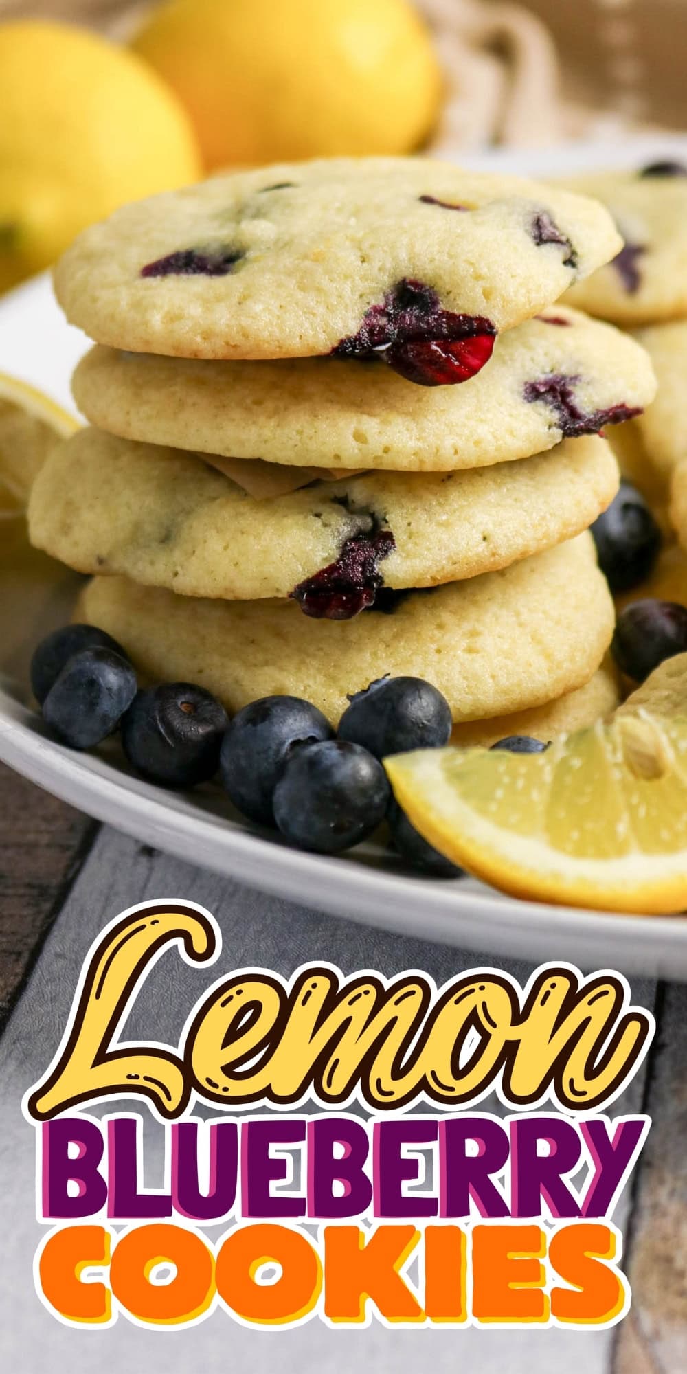 Stack of lemon blueberry cookies with fresh blueberries and lemon slices nearby.