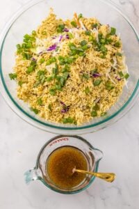 Ramen noodle salad with dressing in measuring cup.