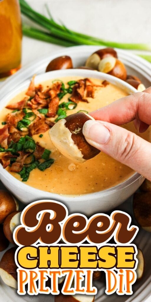 Hand dips a pretzel bite into creamy beer cheese dip topped with bacon and chives.