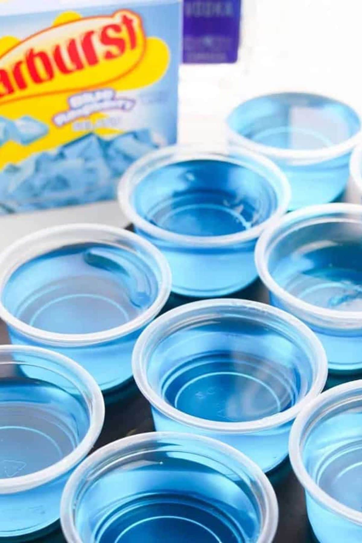 Several clear cups of bright blue liquid, perfect for creative raspberry recipes.