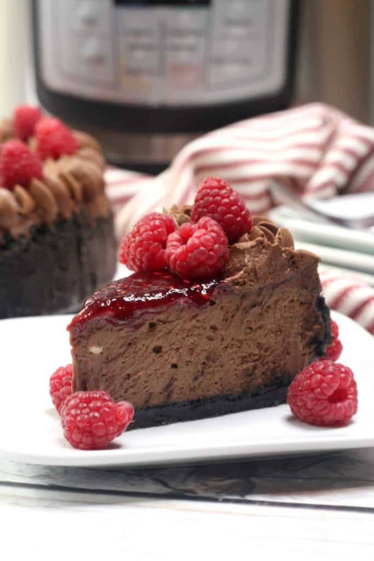 A slice of chocolate cheesecake, perfect for raspberry recipes, on a white plate.