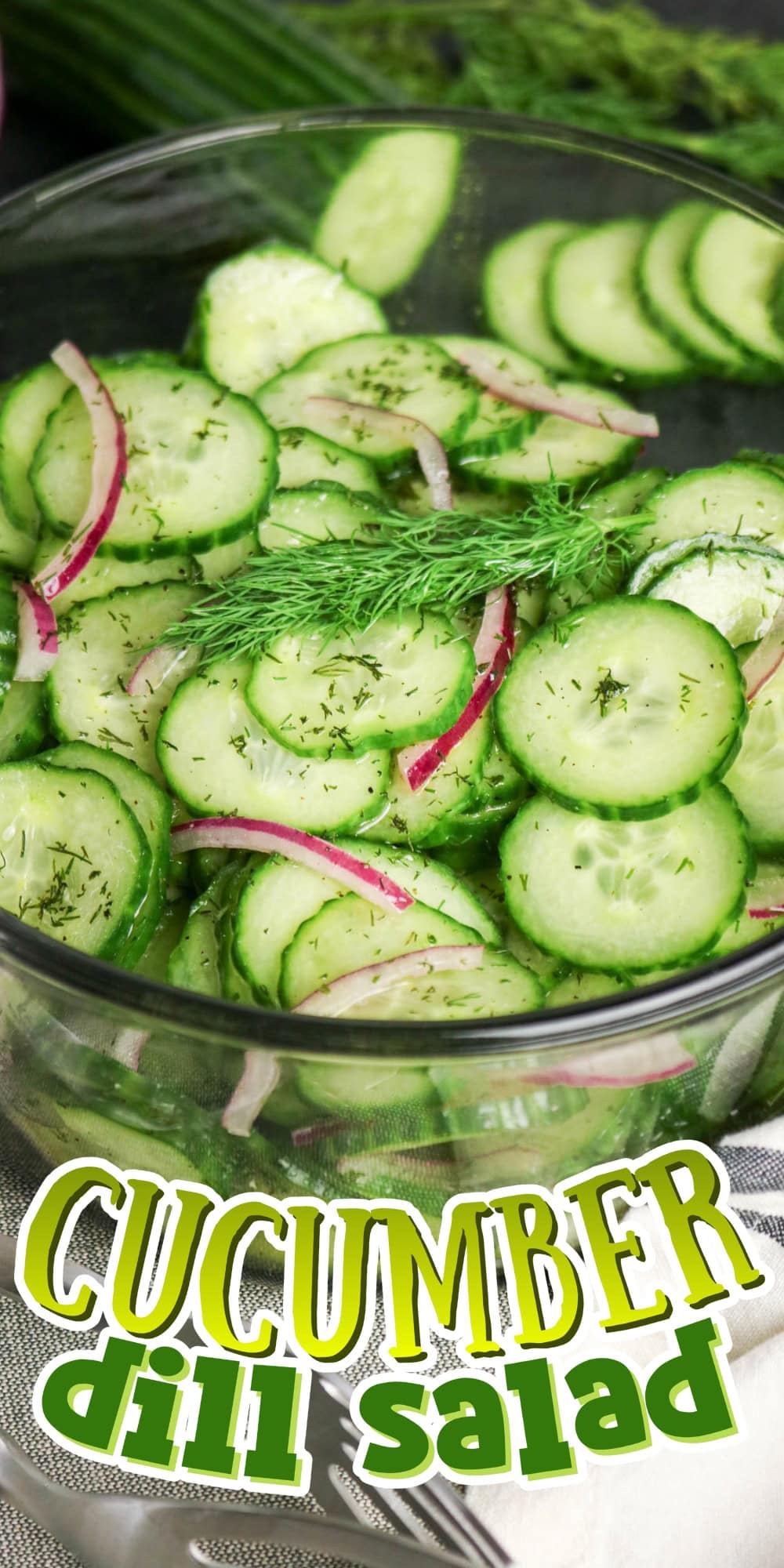 A bowl of cucumber dill salad with red onions and fresh dill garnish.