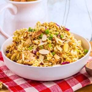 Asian ramen noodle salad with chicken and almonds in a white bowl.