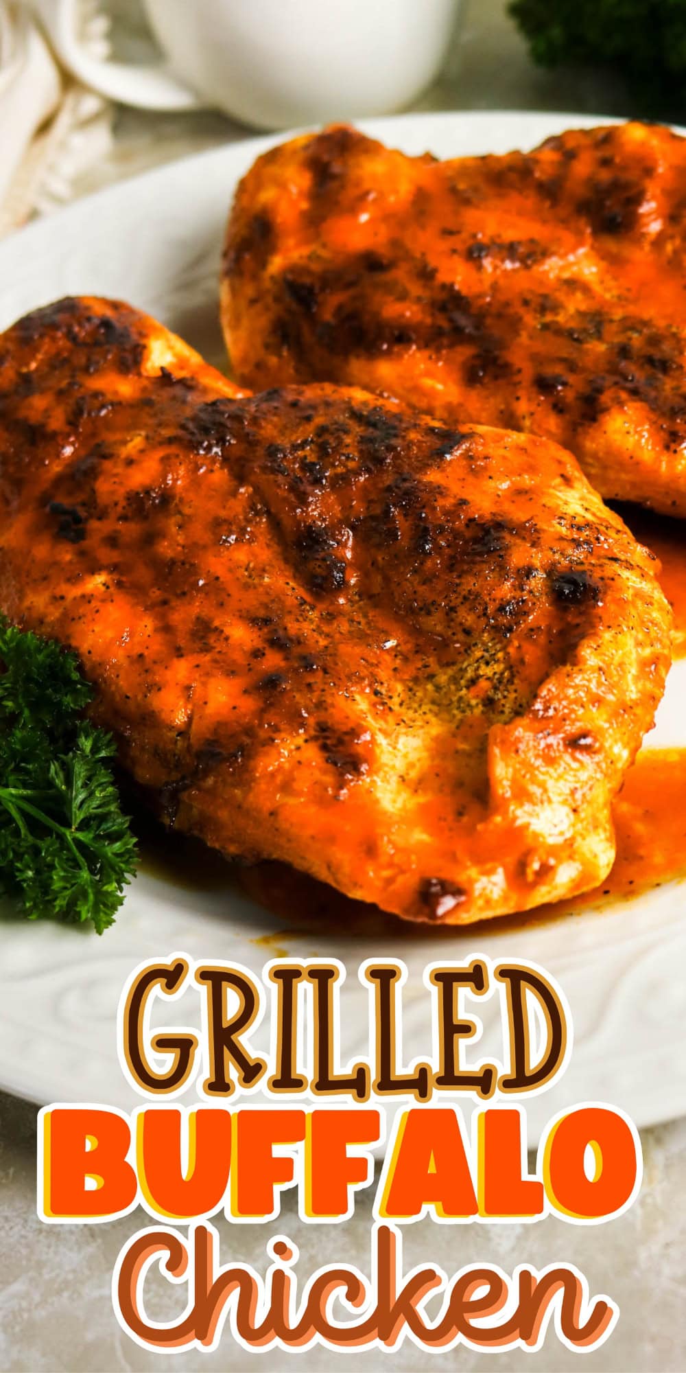 Two pieces of grilled buffalo chicken with sauce on a white plate, garnished with parsley.