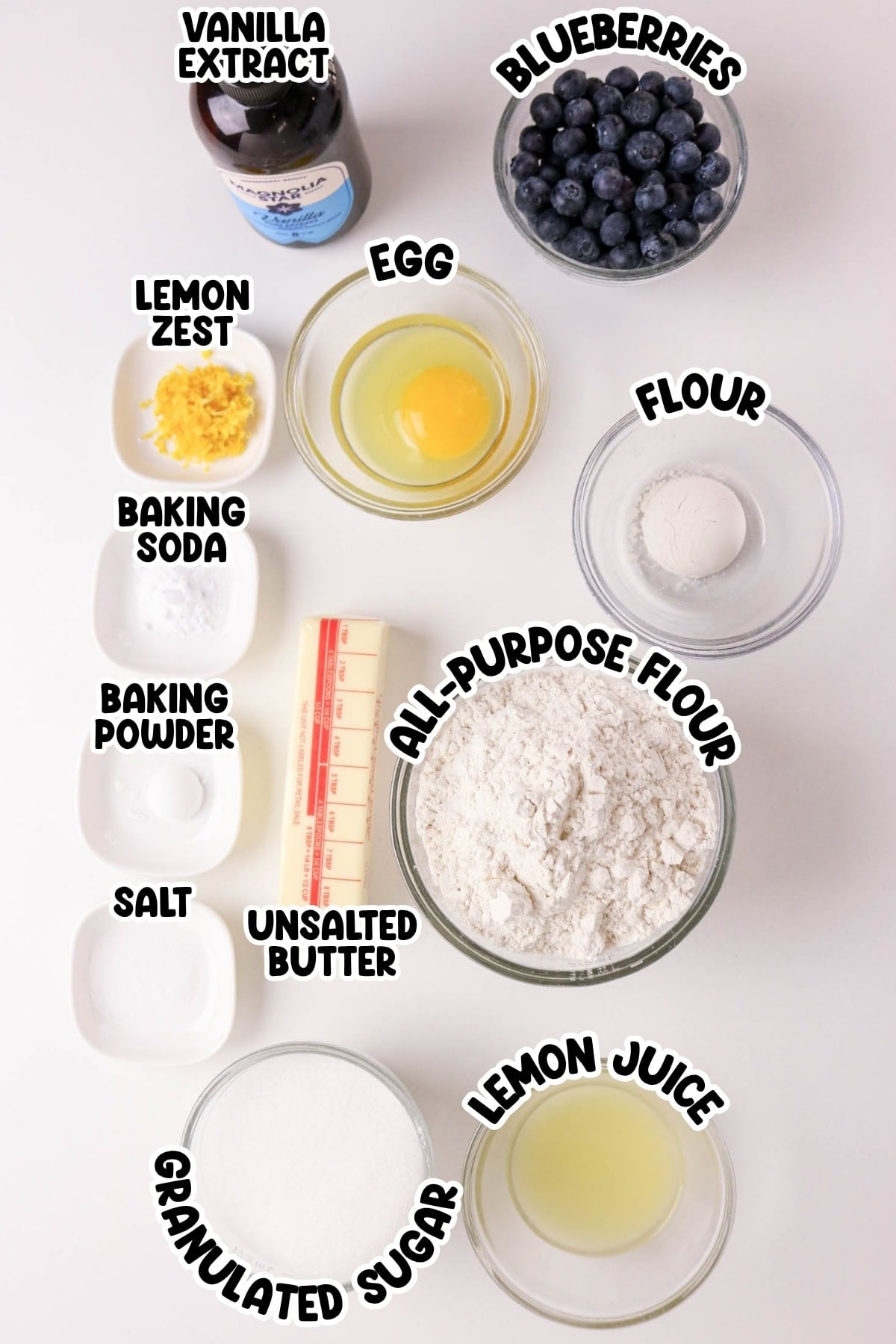 Ingredients for blueberry muffins arranged in bowls, each labeled with its name.