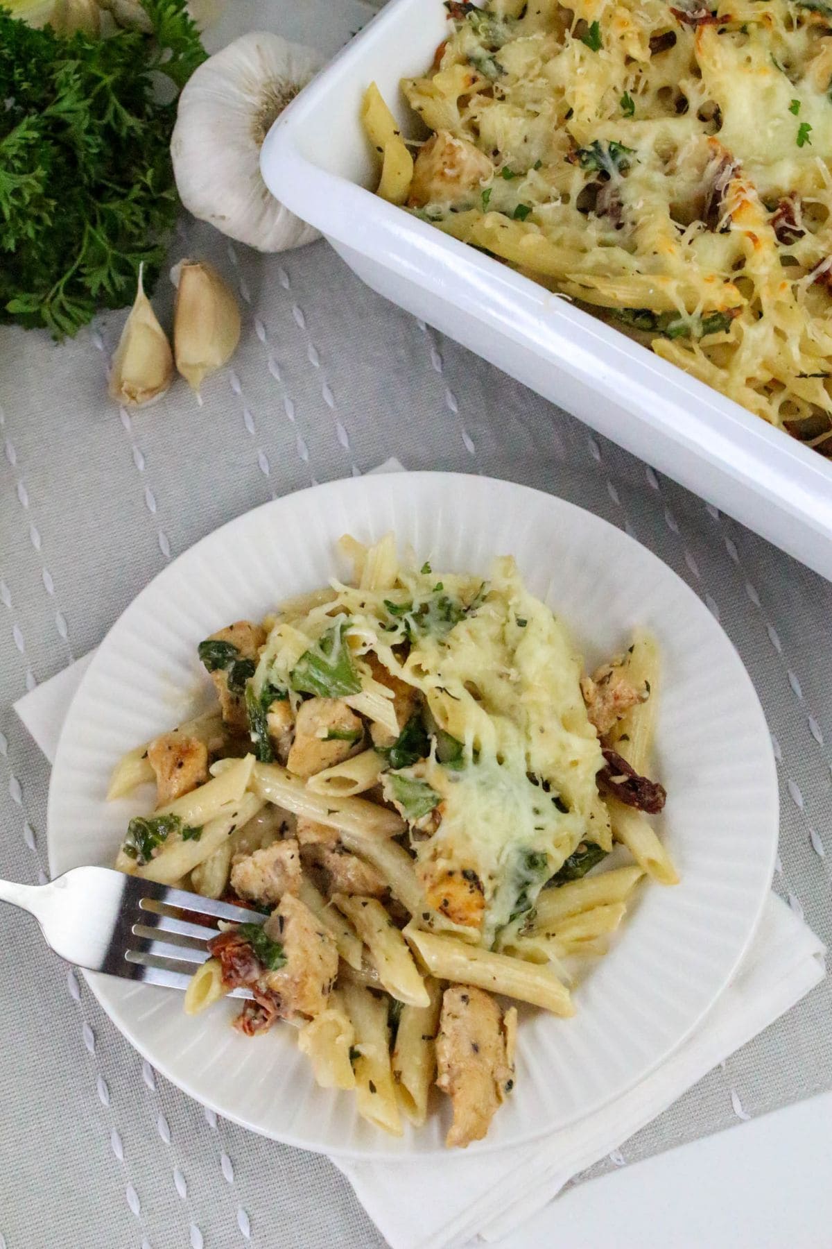 Plate of baked pasta with chicken, spinach, cheese—perfect for chicken casserole recipes.