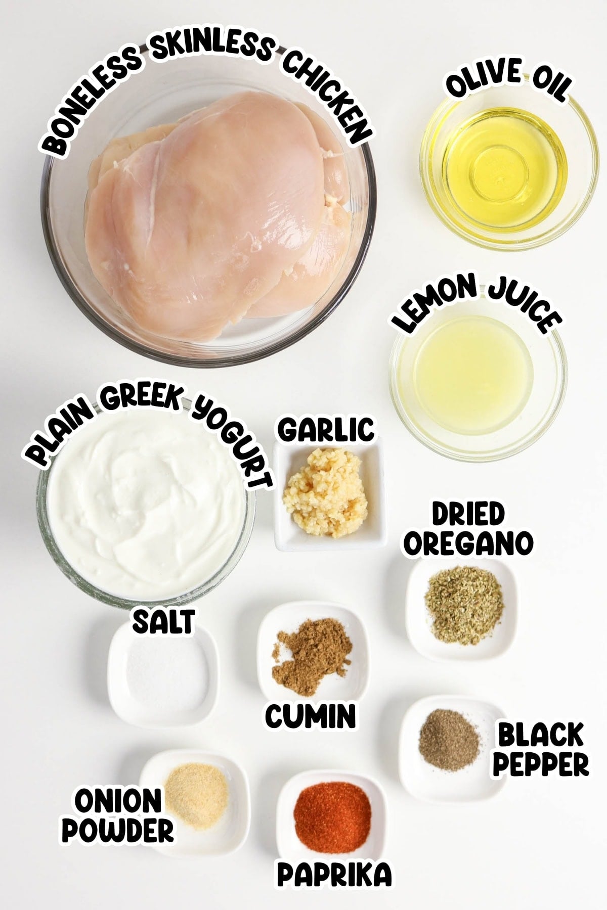 Ingredients for Greek chicken marinade arranged in bowls, labeled with their names.