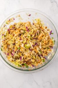 Close-up of Asian chicken salad in a glass bowl.