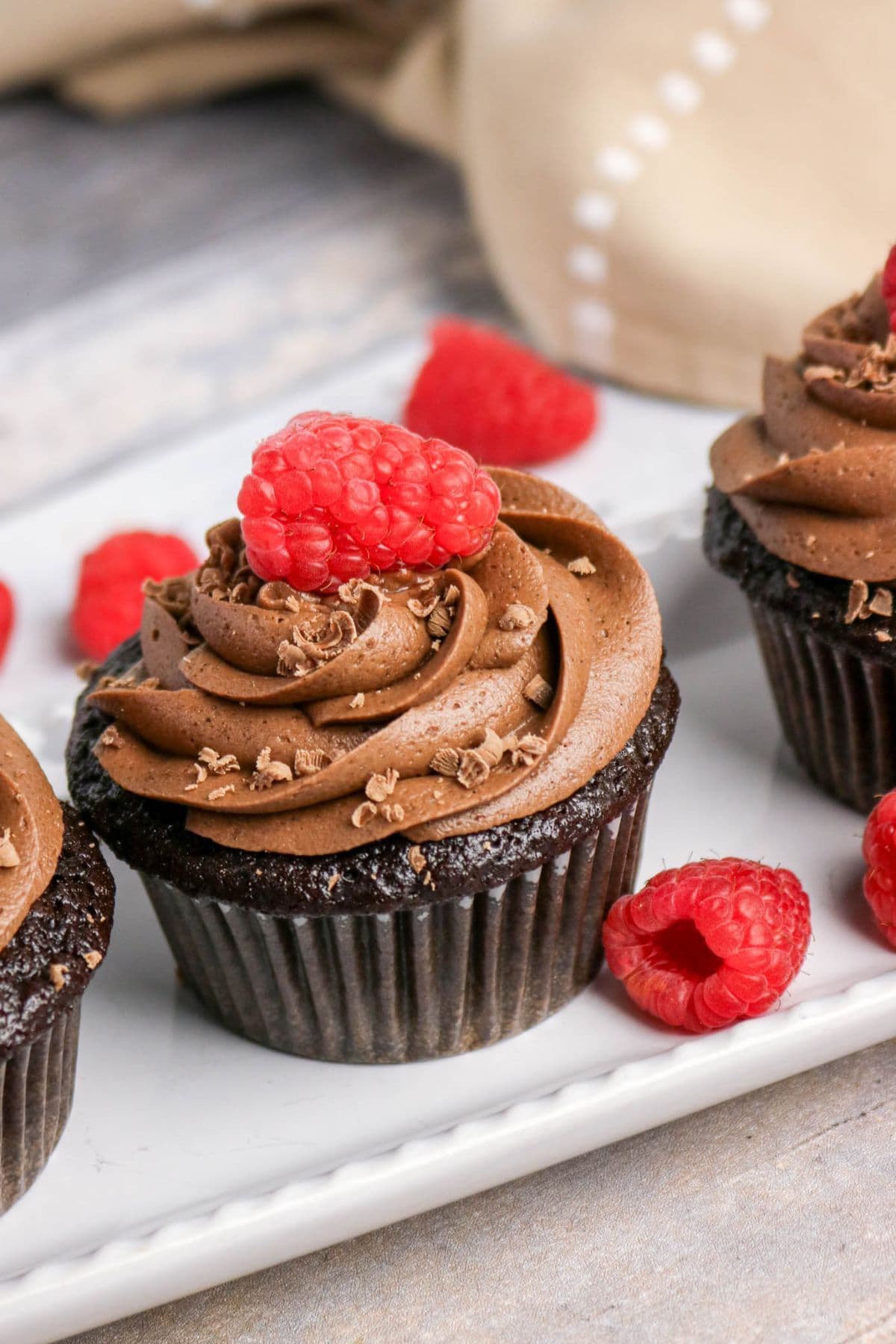 Chocolate cupcakes with chocolate frosting, topped with raspberries—raspberry recipes.