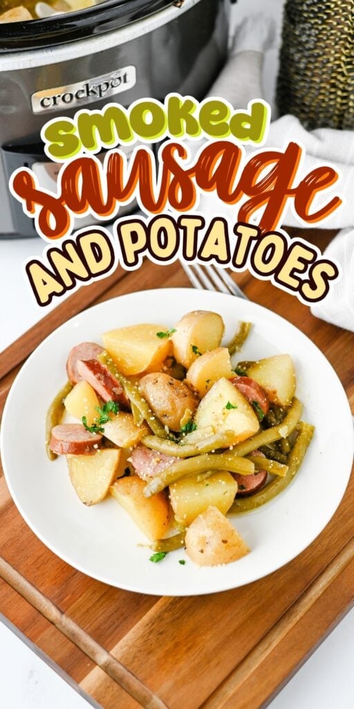A plate of smoked sausage, potatoes, and green beans in front of a crockpot.