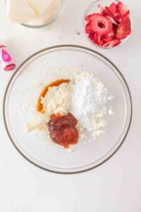 Glass bowl with cream cheese, powdered sugar, vanilla, and fruit spread.