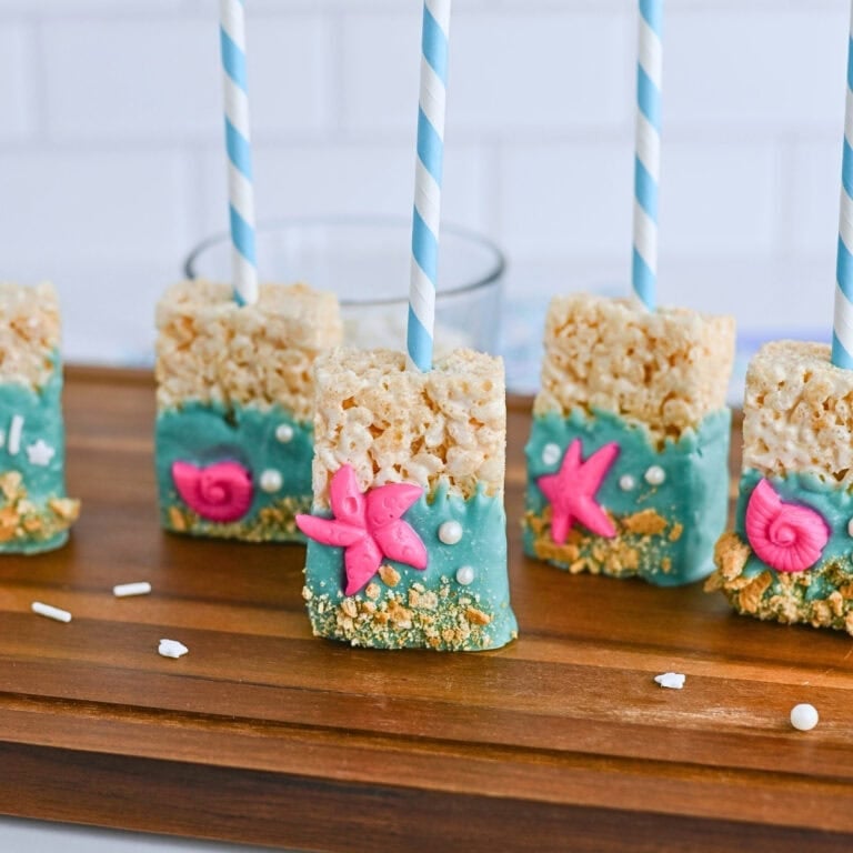 Rice Krispies treats on sticks, decorated with blue icing and pink sea creatures.