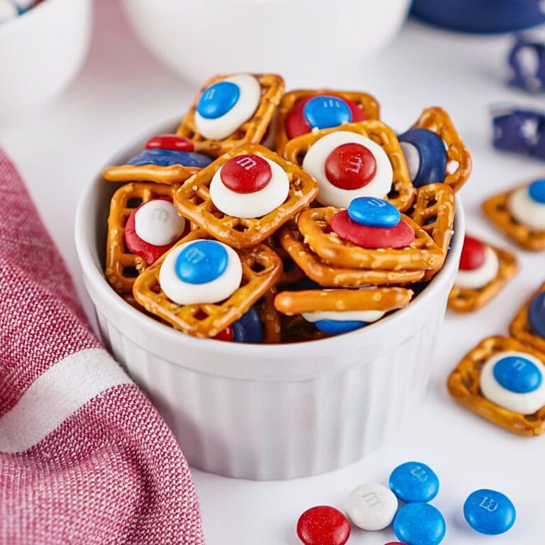 A bowl of pretzel snacks topped with red, white, and blue M&M candies.