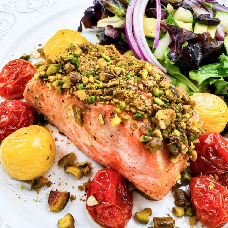 Pistachio-crusted salmon with roasted tomatoes and mixed green salad.
