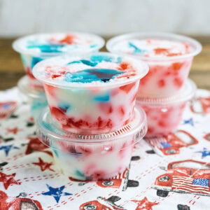 Stacked cups of red, white, and blue frozen treats on a festive napkin.