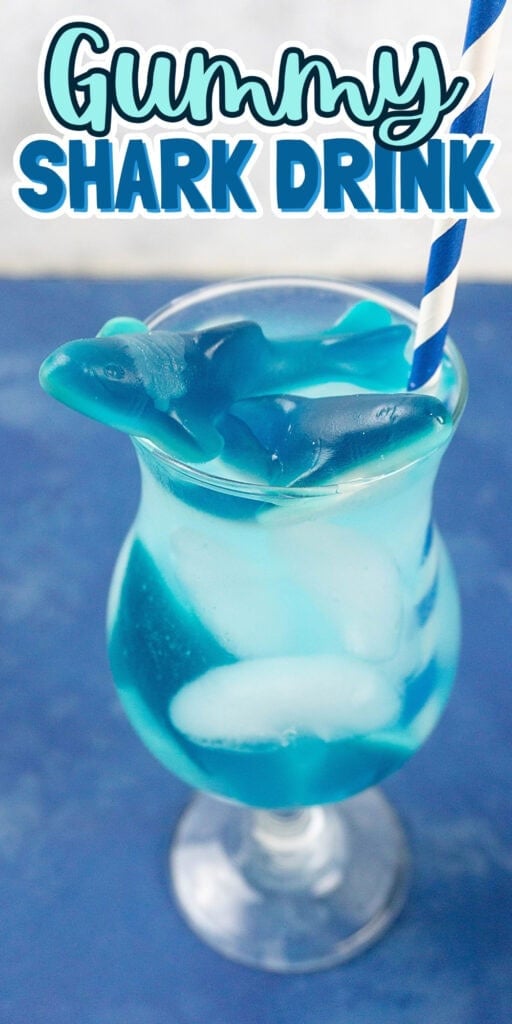 Blue drink with ice, gummy sharks, and a striped straw in a curved glass.