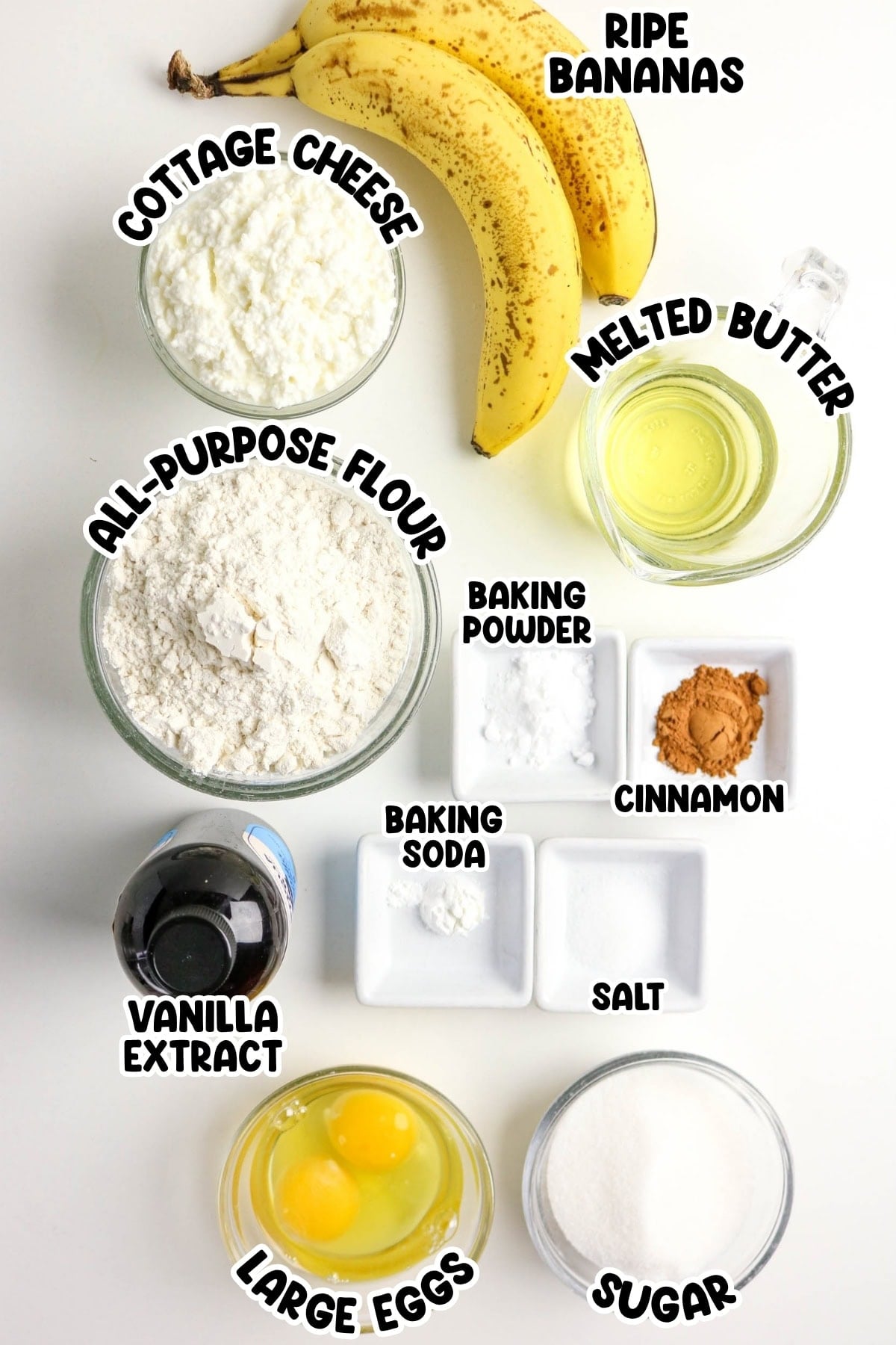 Overhead view of banana bread ingredients in bowls, labeled with bold text.