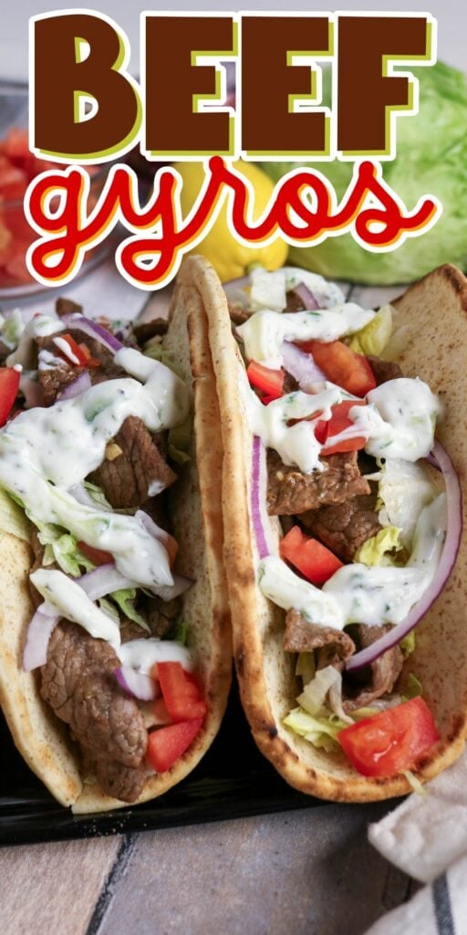 Two beef gyros with lettuce, tomato, onion, and tzatziki sauce in pita bread.