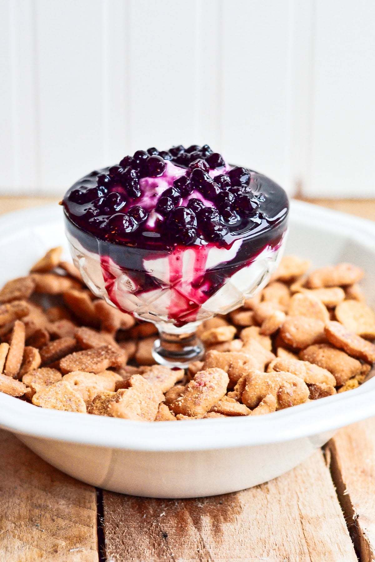 Glass dessert dish with berry topping, surrounded by cinnamon sugar cookies.