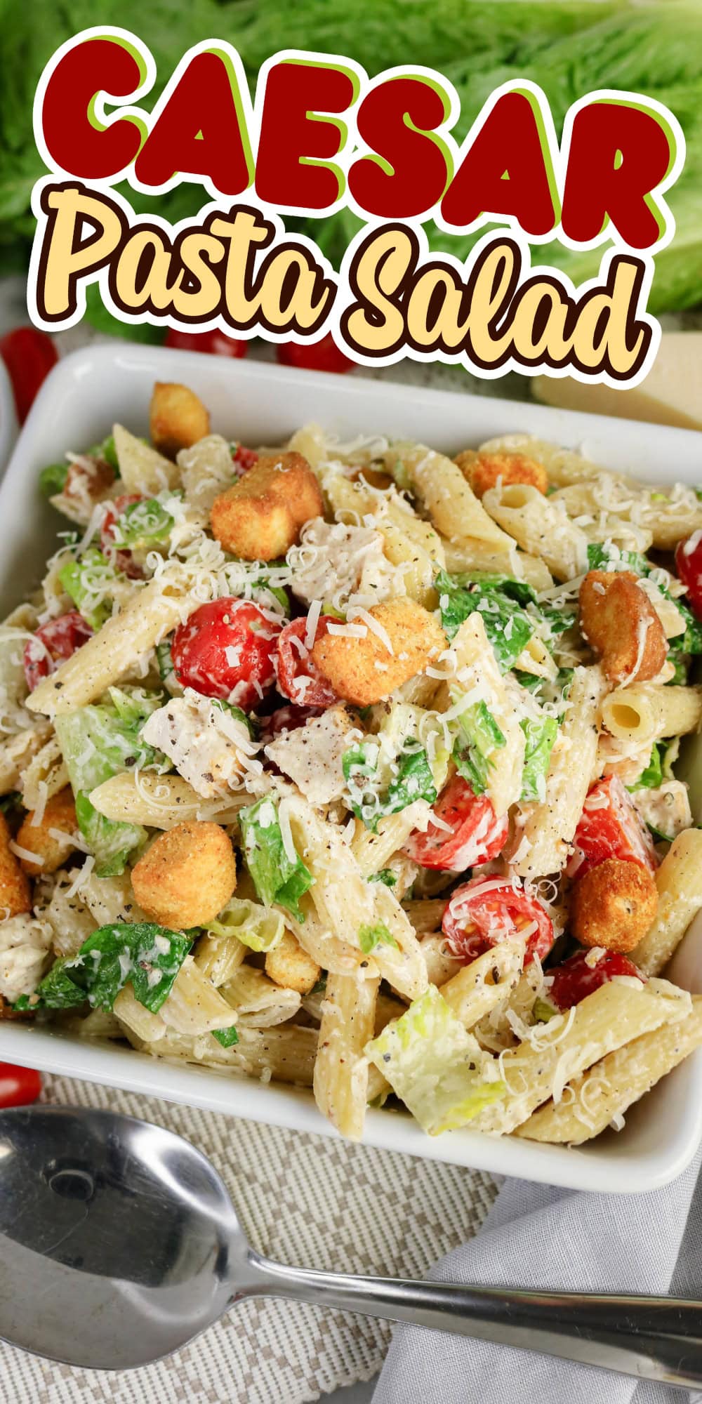 Bowl of Caesar pasta salad with lettuce, tomatoes, croutons, and grated cheese.
