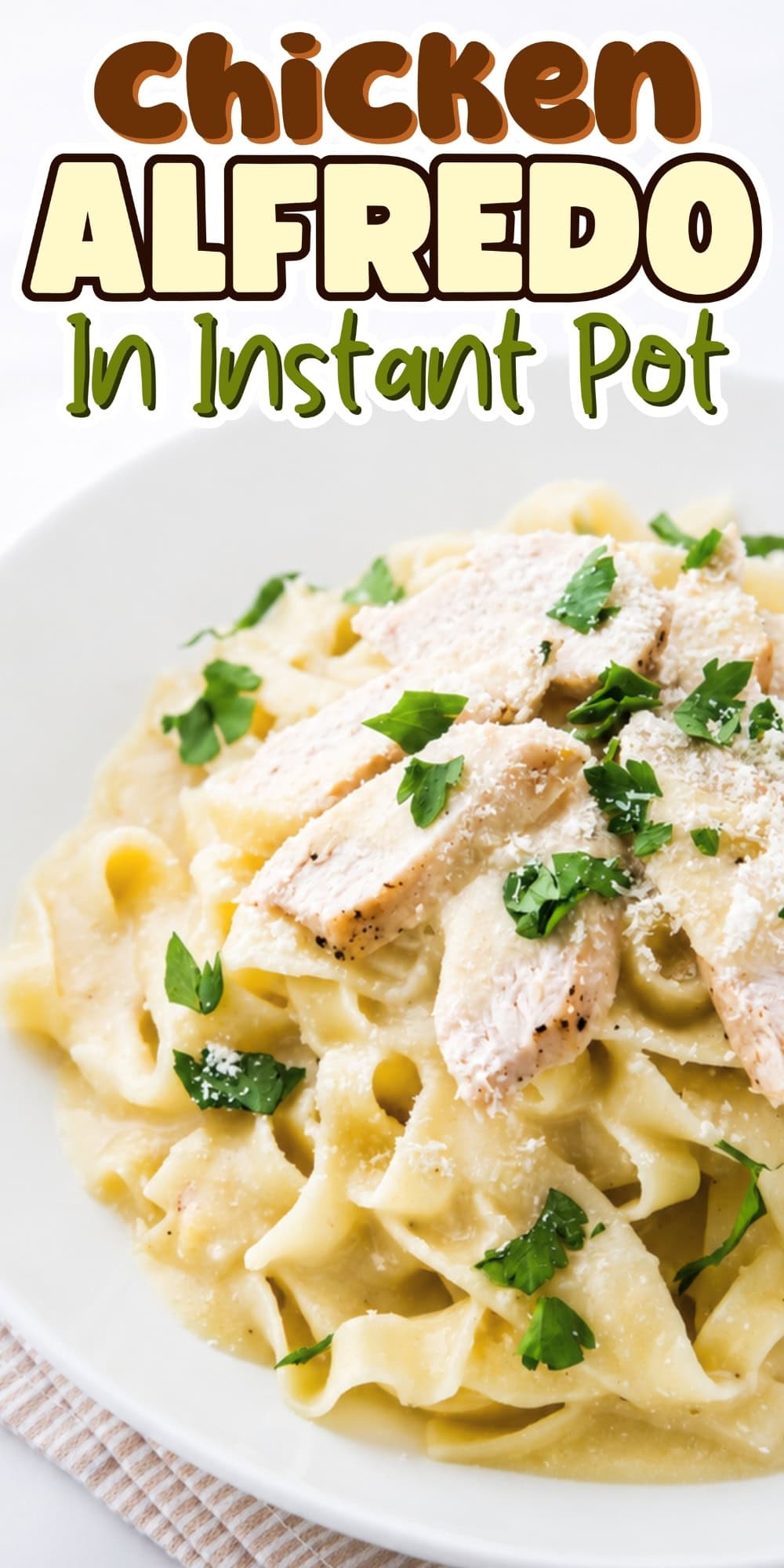 Chicken Alfredo pasta topped with parsley and parmesan on a white plate.