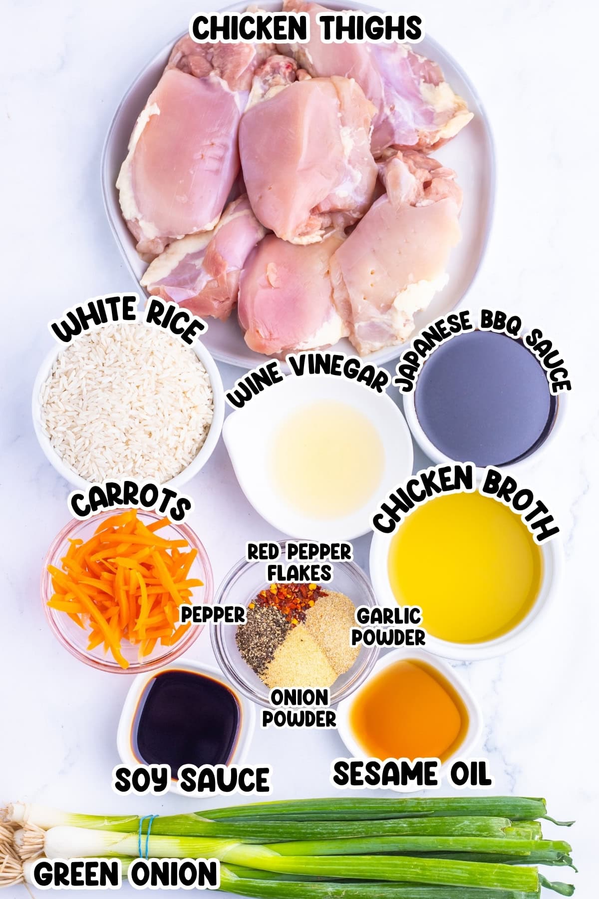 Raw chicken thighs, rice, sauces, broth, spices, carrots, and green onions on a table.