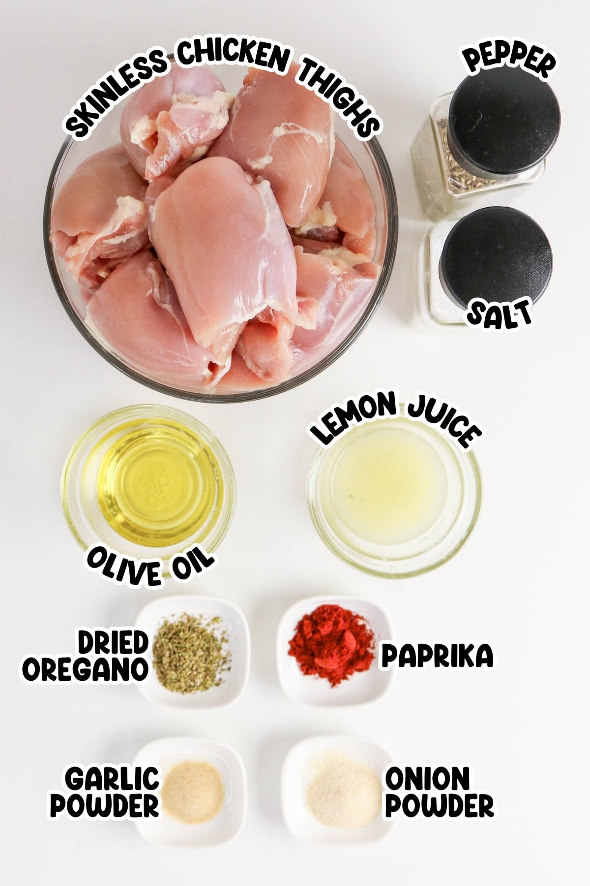 Raw chicken thighs with seasonings and spices arranged in bowls on a white surface.