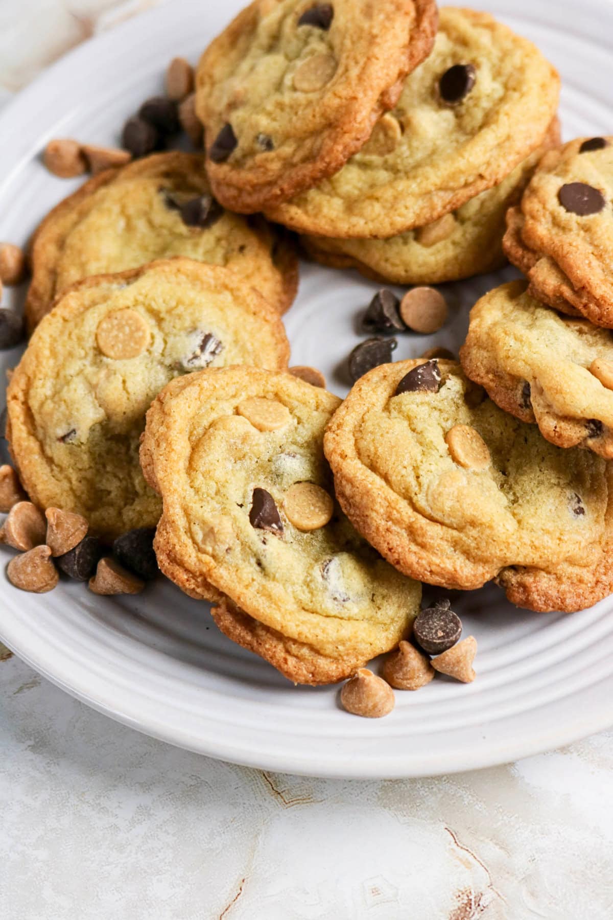 A plate of chocolate chip and peanut butter chip cookies on a white dish.