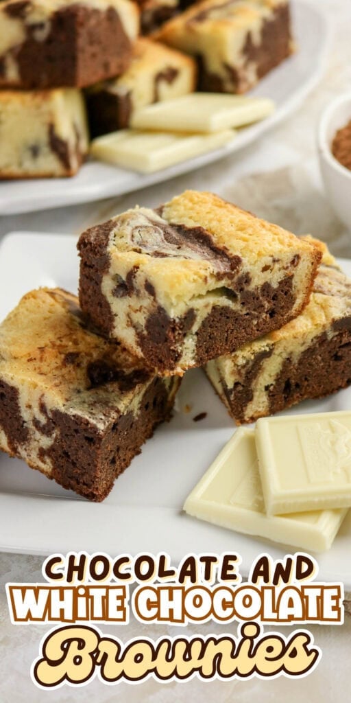 Marbled chocolate and white chocolate brownies on a plate with white chocolate pieces.