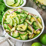 A bowl of cucumber, pineapple, red onion, lime, and cilantro salad.
