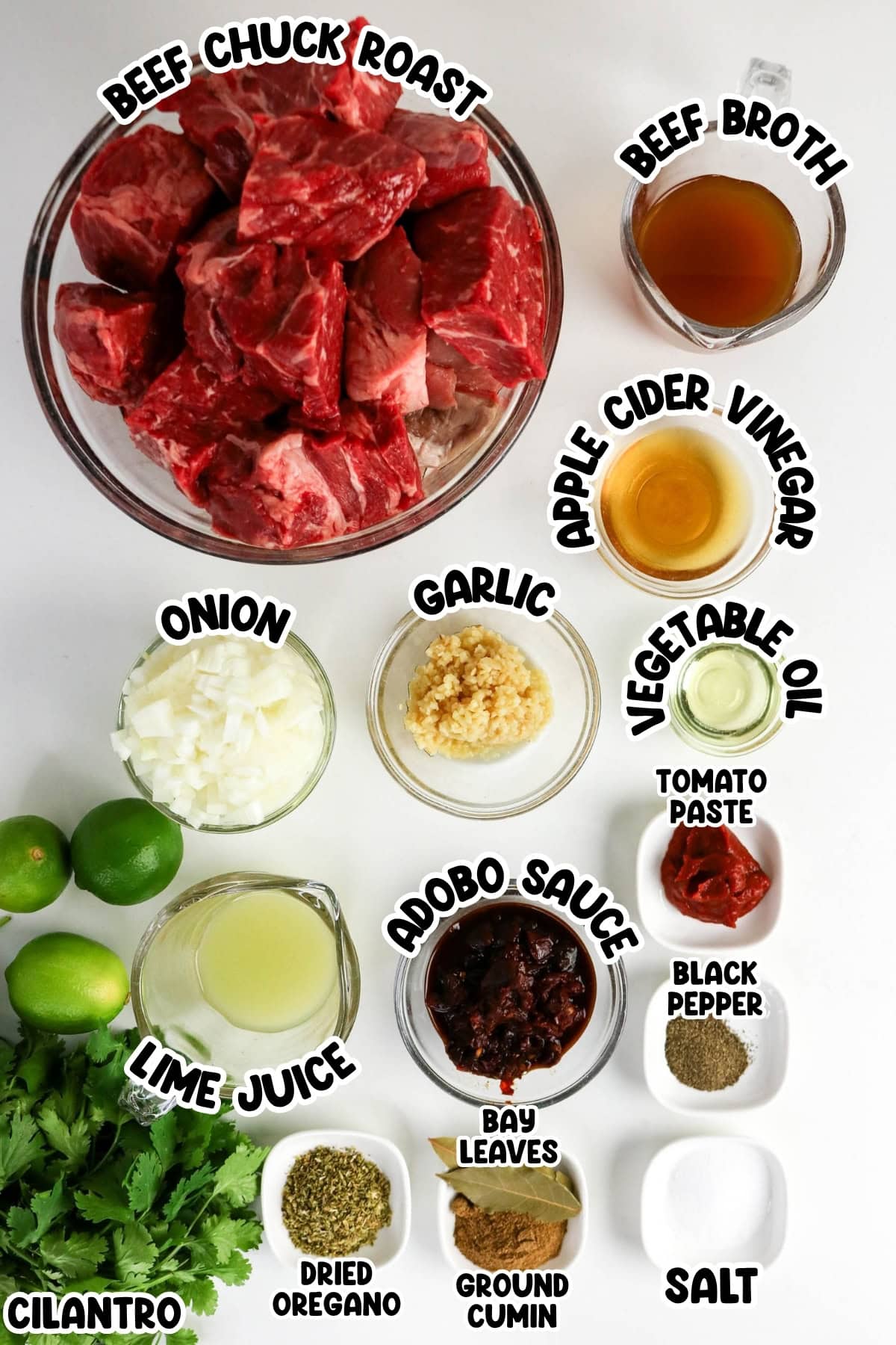 Ingredients for beef stew, including beef, broth, spices, herbs, and sauces on a table.
