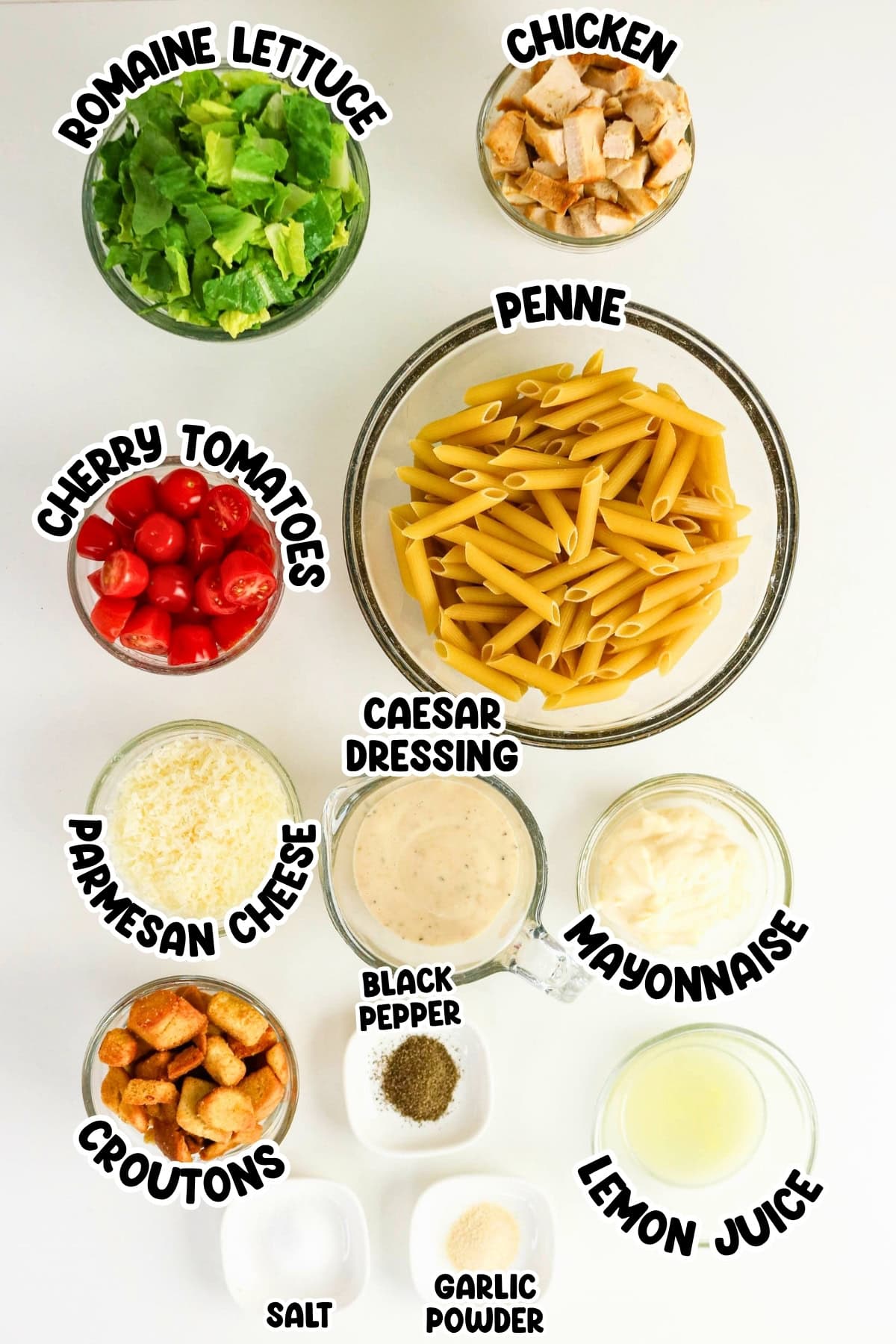 Ingredients for chicken Caesar pasta salad arranged in bowls.