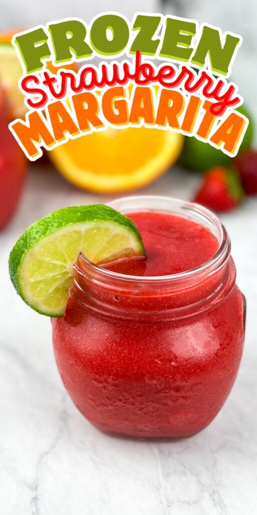 A frozen strawberry margarita in a jar, garnished with a lime slice.