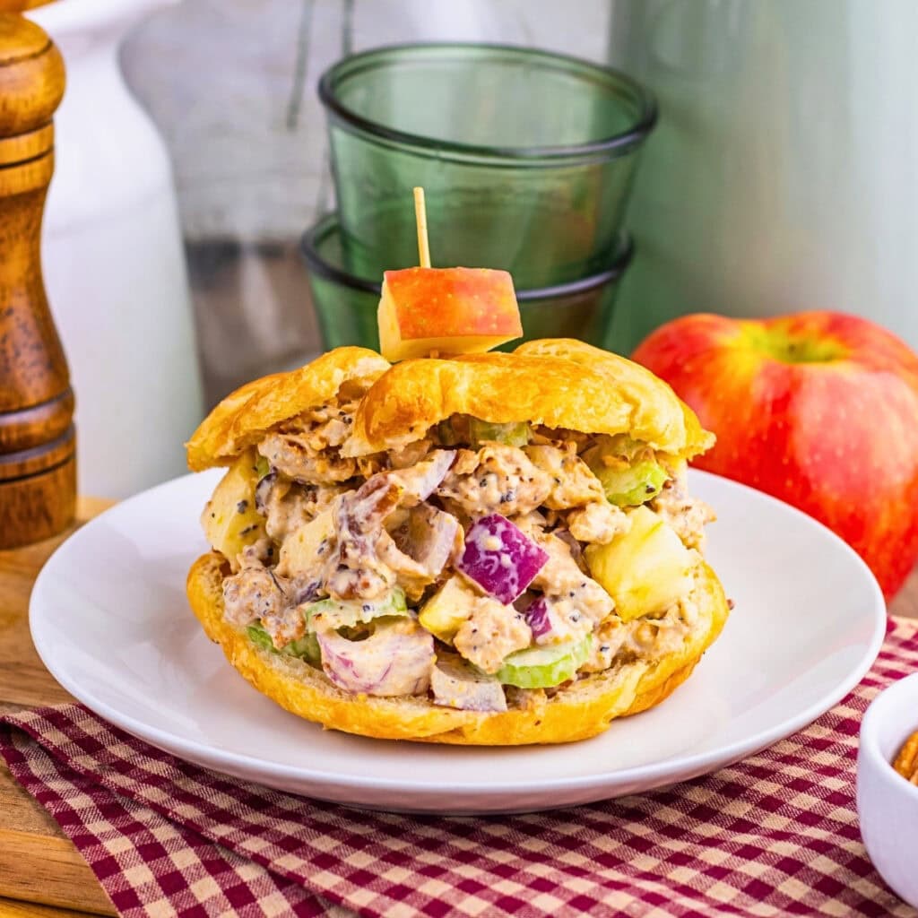 Chicken salad croissant sandwich with apples and celery, garnished with apple cube.