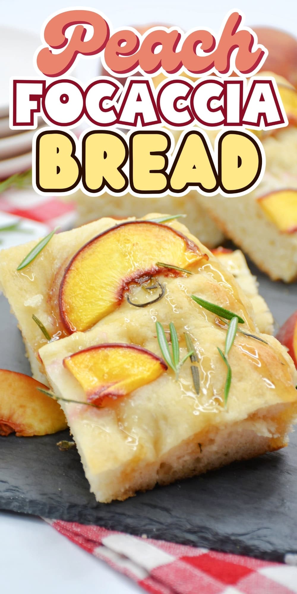Peach focaccia bread topped with peach slices and rosemary on a slate board.