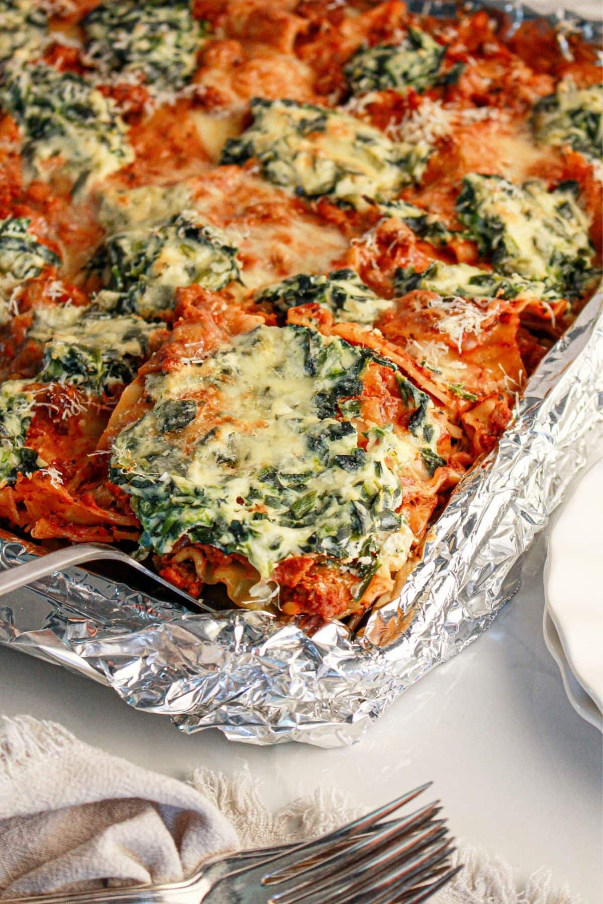 Baked spinach and cheese lasagna, a sheet pan dinner recipe, ready to be served.