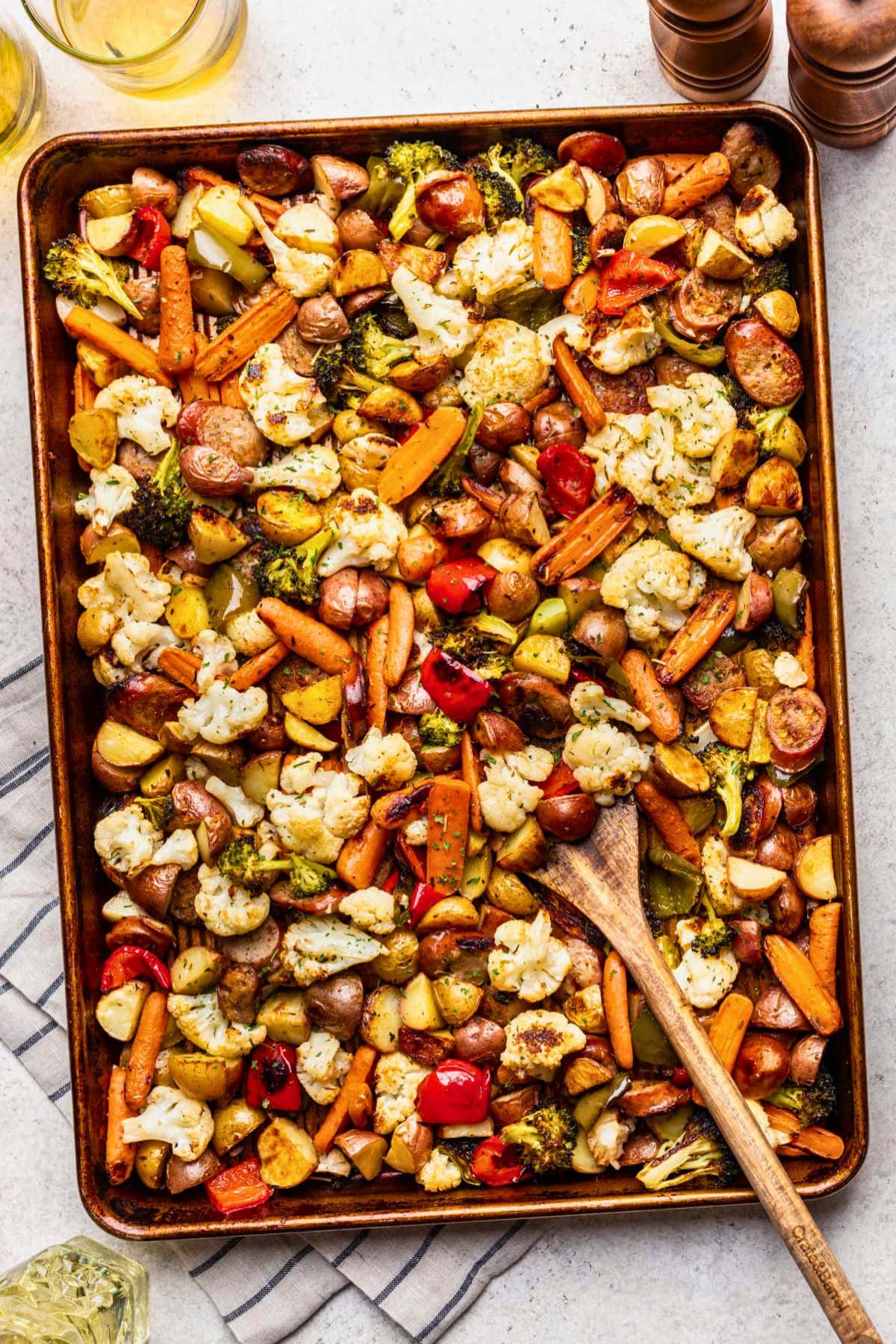 Sheet pan dinner recipes with roasted veggies and sausage, stirred to perfection.