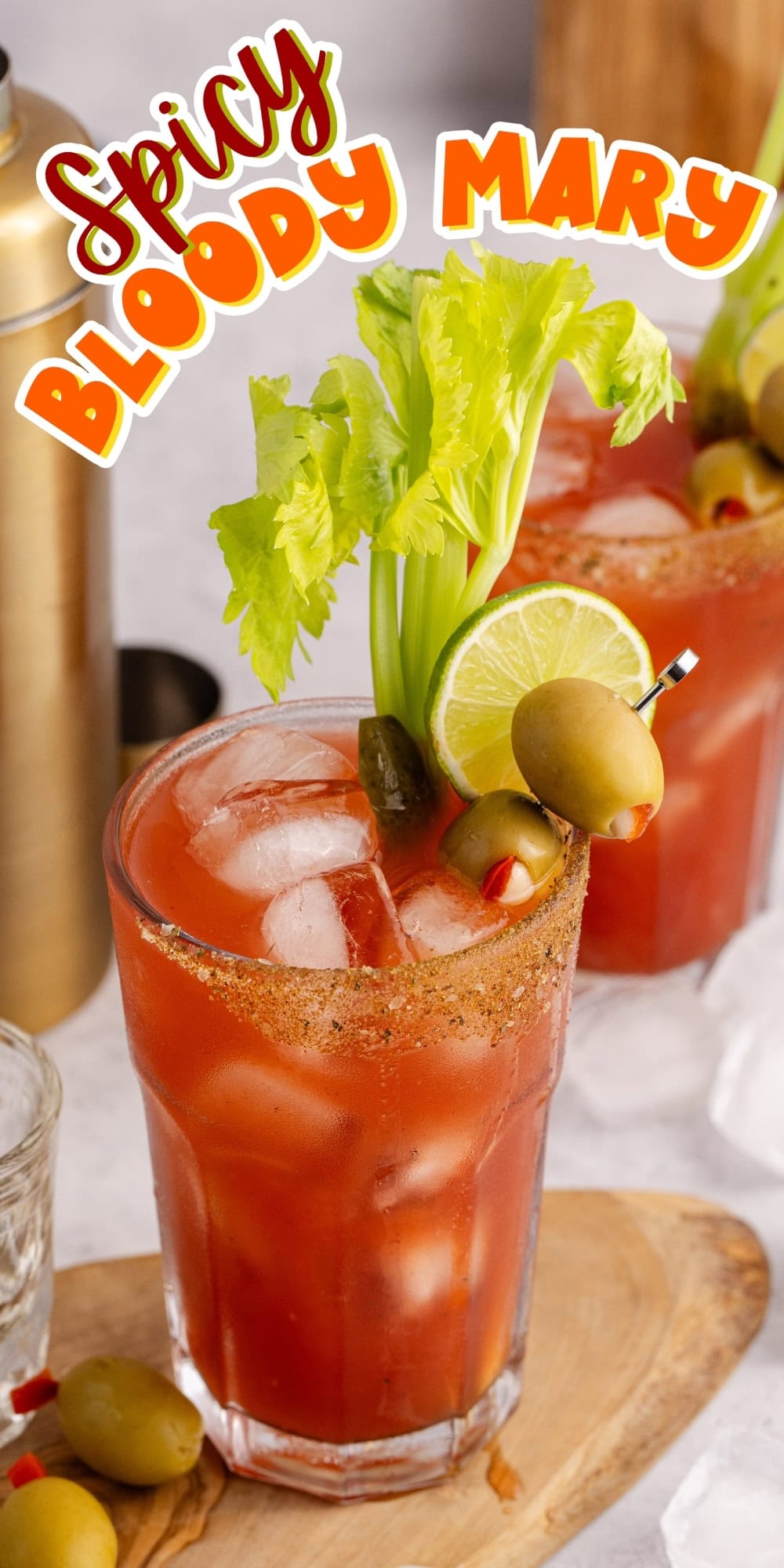 A spicy Bloody Mary cocktail garnished with celery, lime, and olives.