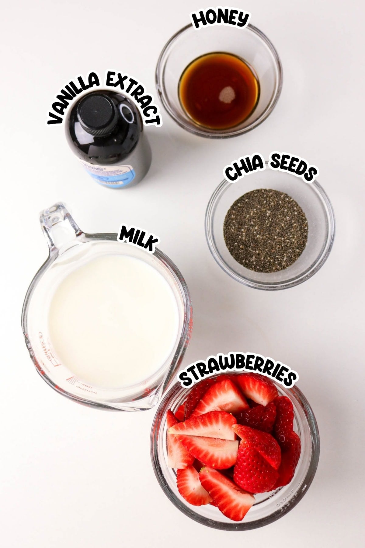 Ingredients in bowls: milk, strawberries, honey, chia seeds, and vanilla extract.