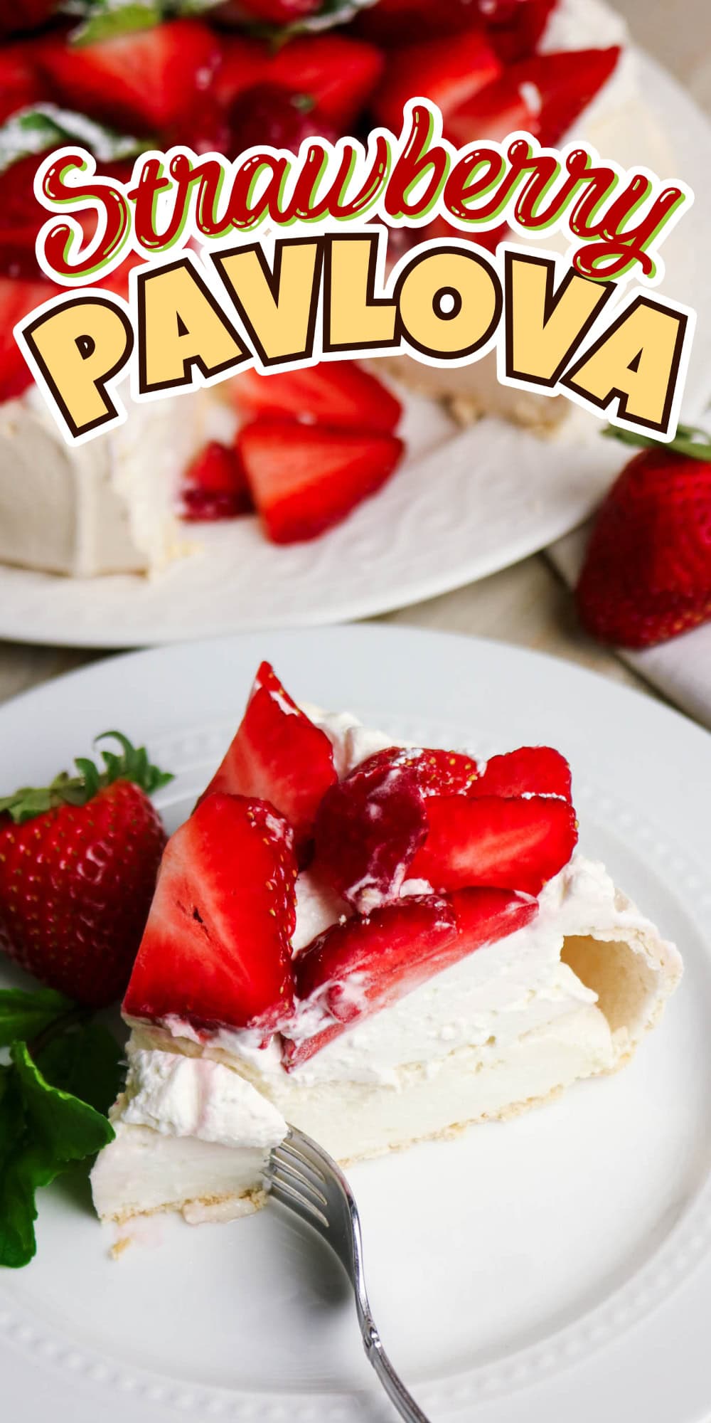 A slice of strawberry pavlova on a plate with fresh strawberries nearby.